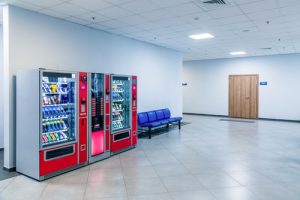 Group,of,red,vending,machines,stands,by,the,wall.,glare